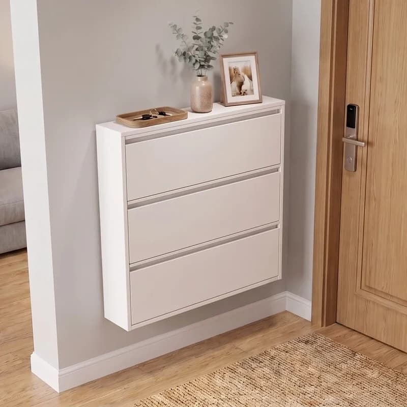 Armário de calçados branco fechado no hall de entrada, com as três frentes lisas e um vaso sobre o tampo